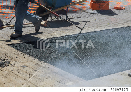 Road with fresh asphalt reconstruction of worker repair asphalt covering 76697175
