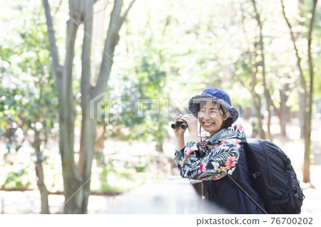 A woman enjoying a hike in the fresh green forest A woman enjoying a hike in the fresh green forest 76700202