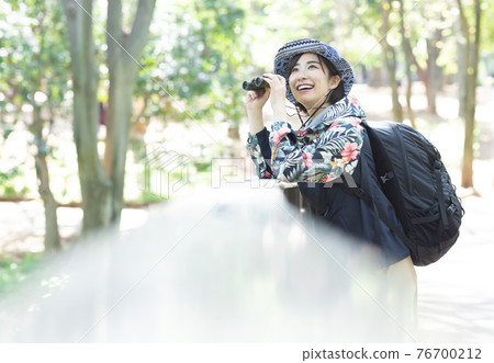 A woman enjoying a hike in the fresh green forest A woman enjoying a hike in the fresh green forest 76700212