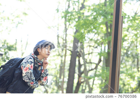A woman enjoying a hike in the fresh green forest 76700386