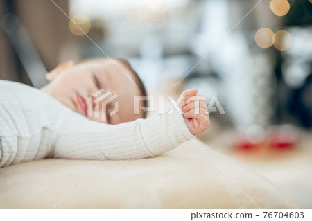 Fingers clenched into fist on hand of sleeping baby Fingers clenched into fist on hand of sleeping baby 76704603