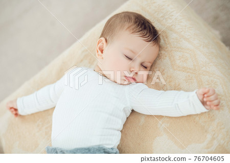 Sleeping cute baby with arms outstretched Sleeping cute baby with arms outstretched 76704605