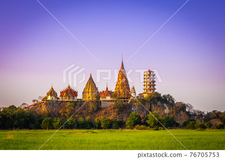 Landscape of Wat Tham Sua at dusk is a very beautiful and popular landmark for tourists in Kanchanaburi, Thailand. 76705753