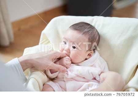 Asian baby eating daddy's finger Asian baby eating daddy's finger 76705972