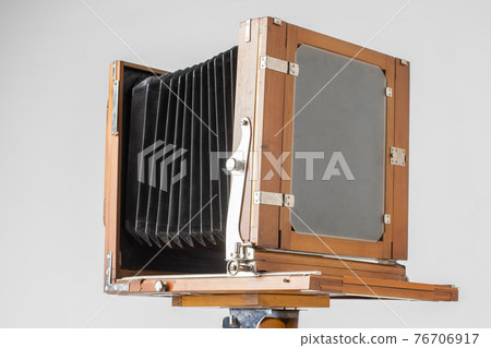An old wooden camera of the last century with an accordion. 76706917