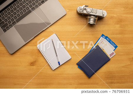 Top view off office photography desk table with laptop, notebook, camera and passport with air ticket. Top view off office photography desk table with laptop, notebook, camera and passport with air ticket. 76706931
