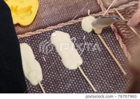 The process of making chocolates on sticks. The process of making chocolates on sticks. 76707960