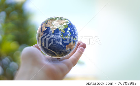 Human hand holds small Earth with care and love. Planet Earth globe ball in human hand. Strong Human  hands support planet. Earth day and saving planet. Environment conservation concept.  76708982