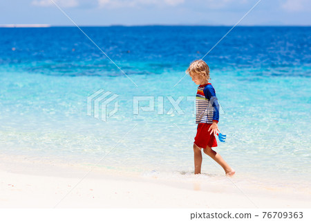 Kids playing on beach. Children play at sea. 76709363