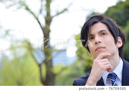 Young man in a pondering suit 76709380