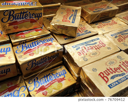 SEREMBAN, MALAYSIA -APRIL 15, 2021: Butter in square packaging is on display on chiller shelves inside the supermarket. Butter is a dairy product made from the fat and protein components of milk. 76709412