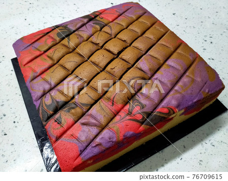 Sponge cake with colourful random patterns. Placed on a white table. Simple cake as a dessert. Sponge cake with colourful random patterns. Placed on a white table. Simple cake as a dessert. 76709615