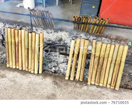 Malaysian famous traditional food called lemang. Glutinous rice wrapped with banana leave and cook & steamed in bamboo. Malaysian famous traditional food called lemang. Glutinous rice wrapped with banana leave and cook & steamed in bamboo. 76710035