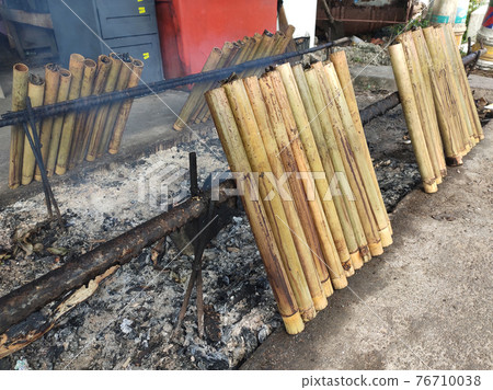 Malaysian famous traditional food called lemang. Glutinous rice wrapped with banana leave and cook & steamed in bamboo.  76710038