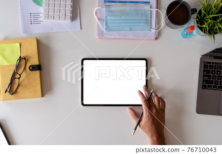 White office desk table with surgical face mask and sanitizer bottle or alcohol gel with calculator isolated on white background, Hand of man using tablet with blank screen at home White office desk table with surgical face mask and sanitizer bottle or alcohol gel with calculator isolated on white background, Hand of man using tablet with blank screen at home 76710043