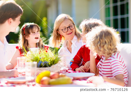 Family eating outdoor. Garden summer fun. 76710126