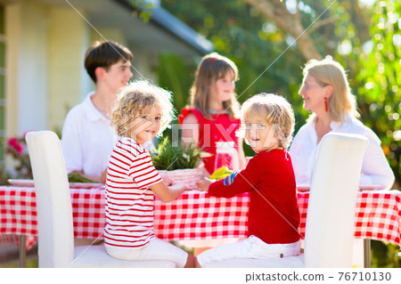 Family eating outdoor. Garden summer fun. Family eating outdoor. Garden summer fun. 76710130