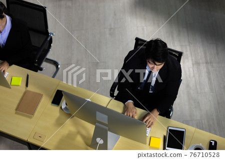 Businessman working overtime in call center office. Concept top view for business at night. Businessman working overtime in call center office. Concept top view for business at night. 76710528