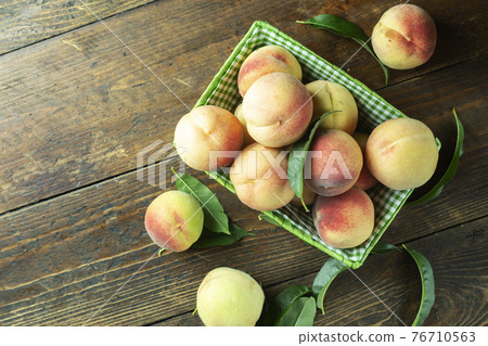 Ripe peaches in basket on wooden background. Home harvest from your own garden. 76710563