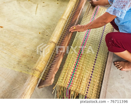 The hands of women woven mats traditional are products handmade in countryside of Thailand. 76711396