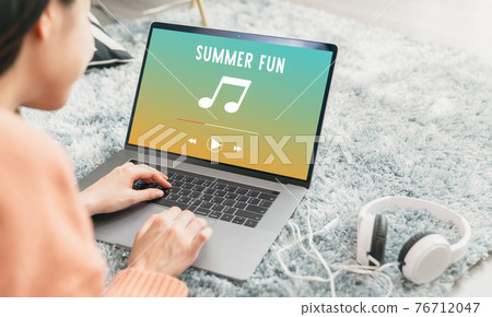 Modern teenagers listening to music with an application from the laptop via the Internet online. Modern teenagers listening to music with an application from the laptop via the Internet online. 76712047