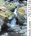 Mountain Shimizu flowing from the rock surface overgrown with moss 76712738