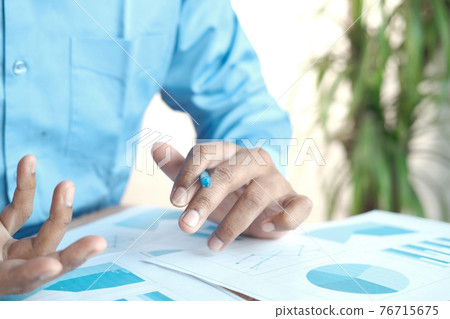 man hand with pen analyzing bar chart on paper man hand with pen analyzing bar chart on paper 76715675