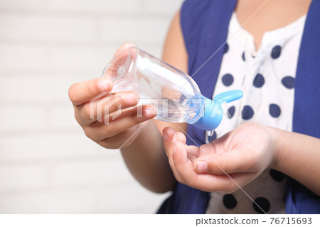 child girl hand using sanitizer gel for preventing virus with copy space  76715693