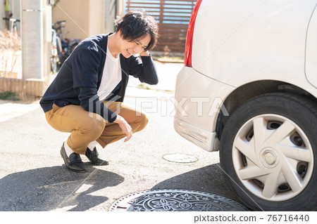 A man who is depressed by scratching a car A man who is depressed by scratching a car 76716440