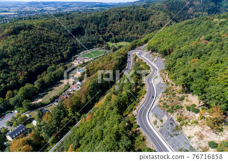 Winding road serpentine from a high mountain pass in the rhine village Bendorf Sayn Germany Aerial view 76716858