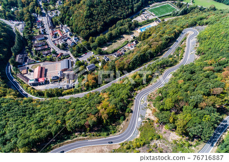 Winding road serpentine from a high mountain pass in the rhine village Bendorf Sayn Germany Aerial view Winding road serpentine from a high mountain pass in the rhine village Bendorf Sayn Germany Aerial view 76716887