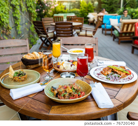 Tasty meals, cocktail, bread on the terrace restaurant table Tasty meals, cocktail, bread on the terrace restaurant table 76720140