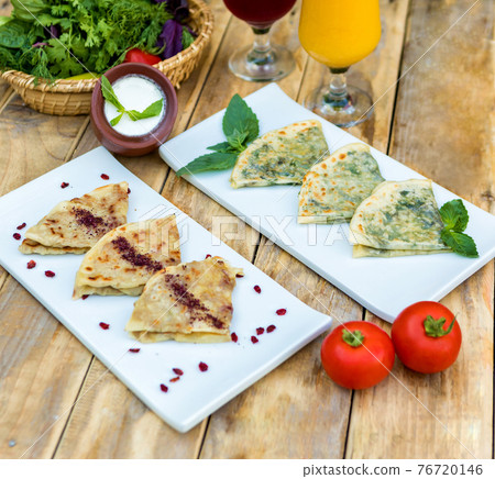 Tasty qutab, Azerbaijani meal with yogurt on the wooden plate Tasty qutab, Azerbaijani meal with yogurt on the wooden plate 76720146