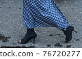Detail of a fashionable outfit woman wearing black shoes and blue plaid long skirt 76720277