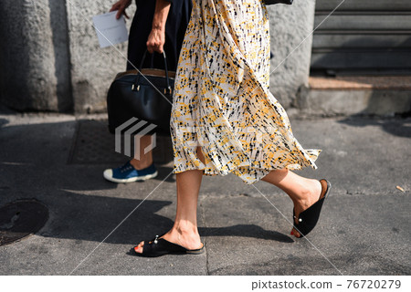 Detail of a fashionable outfit woman wearing colorful dress and summer shoes Detail of a fashionable outfit woman wearing colorful dress and summer shoes 76720279