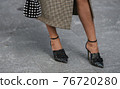 Detail of a fashionable outfit woman wearing black shoes and plaid coat 76720280
