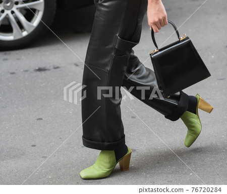 Detail of a fashionable outfit woman wearing green shoes, black handbag and black leather pants Detail of a fashionable outfit woman wearing green shoes, black handbag and black leather pants 76720284