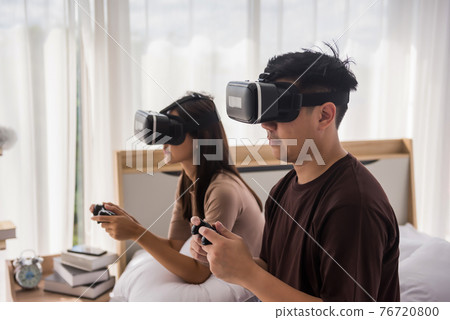 Couple play game with VR glasses in bedroom 76720800
