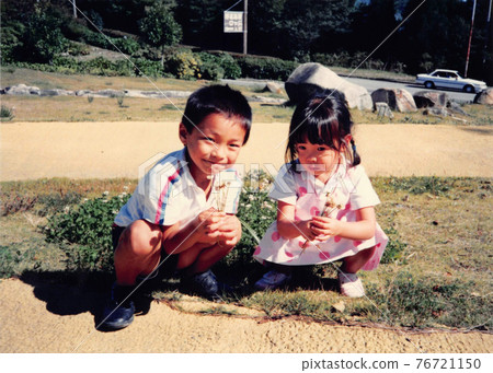 Brothers of boys and girls picking white clover 76721150