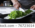 Woman is cutting kale cabbage on the kitchen 76723014