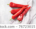 Red sweet peppers on the light grey table. 76723015