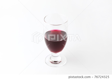 Red wine poured into a glass white background 76724325