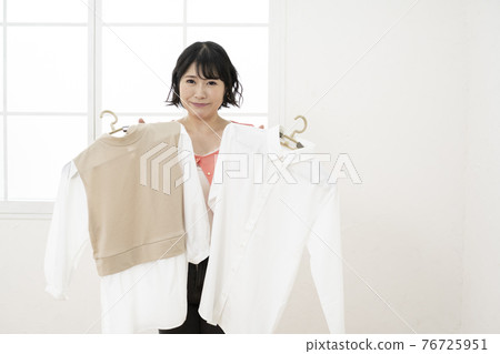 A woman who chooses which clothes to wear A woman who chooses which clothes to wear 76725951