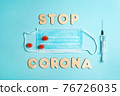 Words STOP CORONA from wooden letters, syringe and facemask. Vaccination and the end of epidemic concept. 76726035