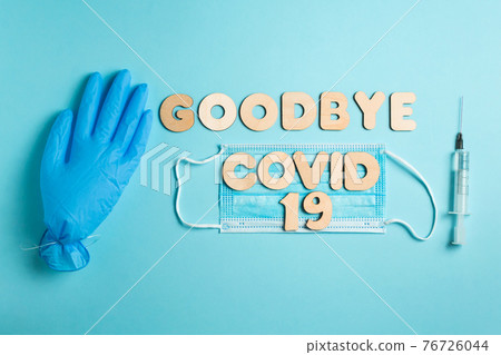 Words GOODBYE COVID 19 and syringe, inflated medical glove and facemask. vaccine and the end of epidemic concept. Words GOODBYE COVID 19 and syringe, inflated medical glove and facemask. vaccine and the end of epidemic concept. 76726044