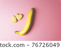 Two cookies in shape of a heart next to each other and banana on a pink background. The concept of Valentine's Day. 76726049
