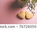 Two cookies in shape of a heart next to each other on a pink background. The concept of Valentine's Day. 76726050