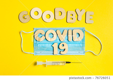 Words GOODBYE COVID 19 from wooden letters, syringe and facemask. Vaccination and the end of epidemic concept. Words GOODBYE COVID 19 from wooden letters, syringe and facemask. Vaccination and the end of epidemic concept. 76726051