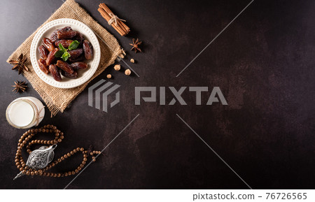 Table top view image of decoration Ramadan Kareem, dates fruit, aladdin lamp and rosary beads on dark stone background. Flat lay with copy space. 76726565