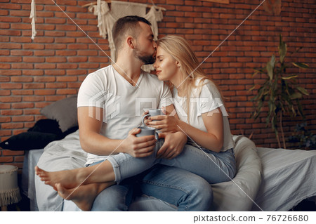 Couple sitting on a bed in a room 76726680